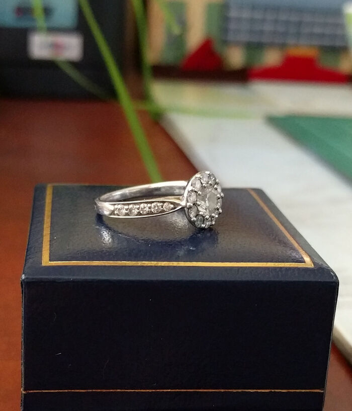 Silver diamond ring resting on a navy box with blurred background, symbolizing strange and disturbing things found in elevator pits