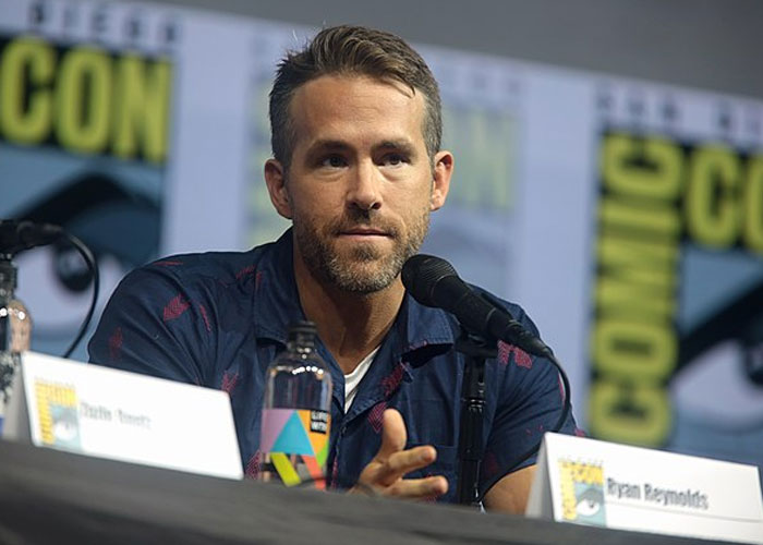 Ryan Reynolds speaking at a panel, representing beloved celebrities that are not that nice in real life according to fans.