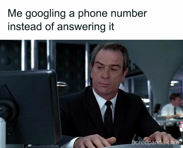 Man in suit looking at computer screen illustrating relatable adulting meme about avoiding phone calls by googling numbers.
