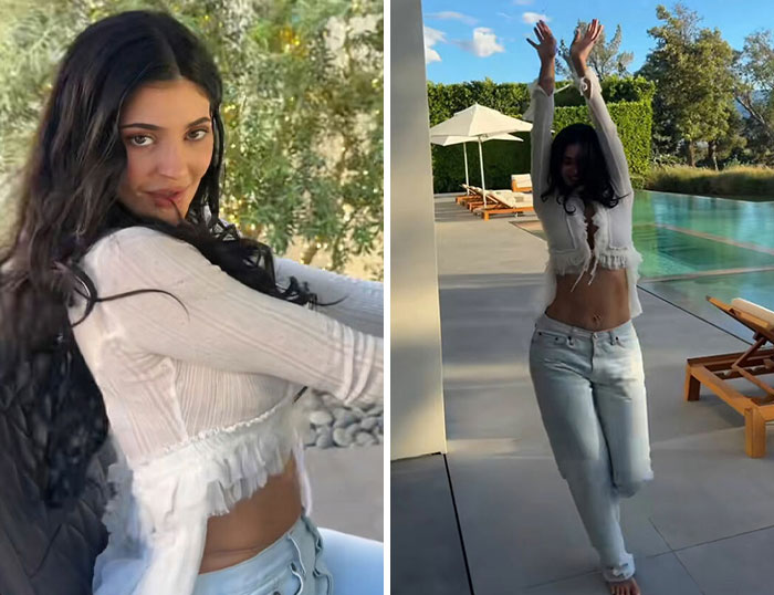 Young woman in white blouse and jeans dancing by poolside, capturing fun and memorable moments from Coachella 2026.