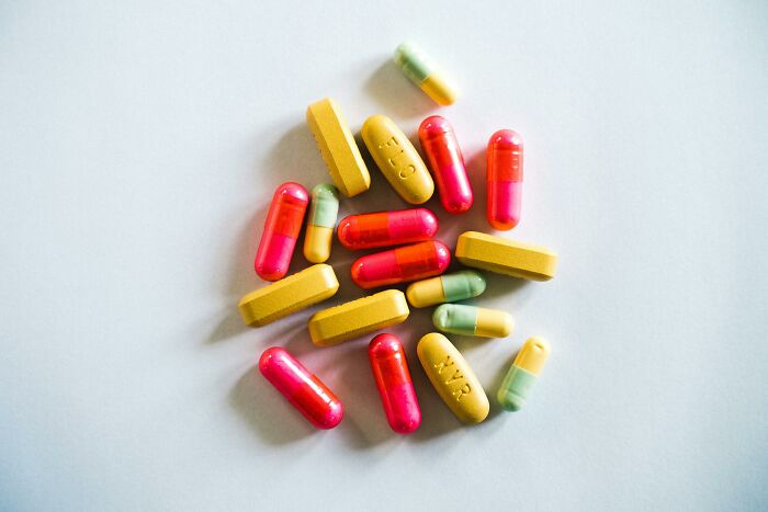 A pile of colorful pills and capsules on a light background, symbolizing workplace incidents and their lasting impact.