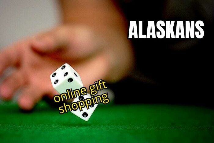 A hand rolls two dice on a green felt table, with "online gift shopping" written on the dice and "ALASKANS" above. Hilarious memes for Alaska.