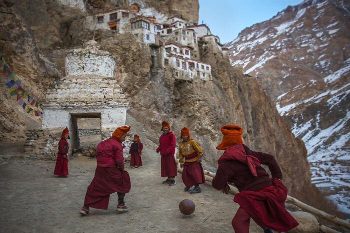 Young Monks Playing Football By Andrew Newey