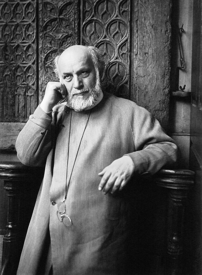 Black and white portrait of a thoughtful bearded man wearing glasses, representing rare and interesting photos from the past.