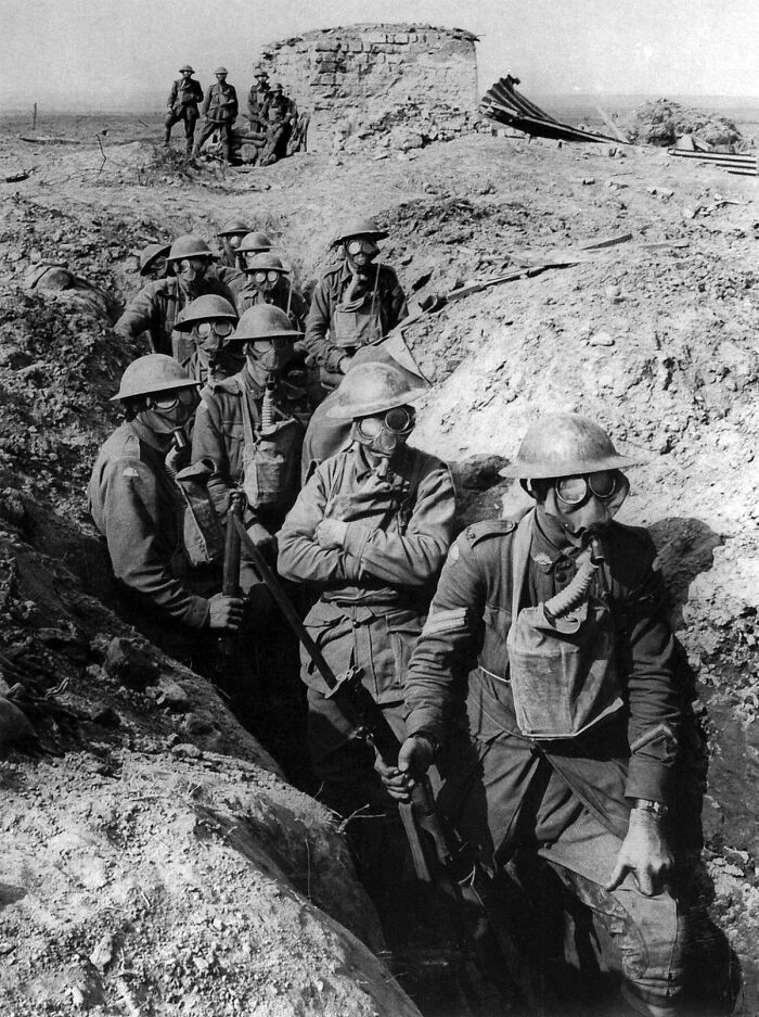 World War I soldiers wearing gas masks in a trench, showcasing rare and interesting historical wartime moments.