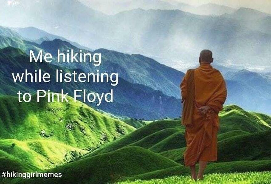 Person in an orange robe hiking alone on green hills with mountains in the background, hiking memes related to nature and music.