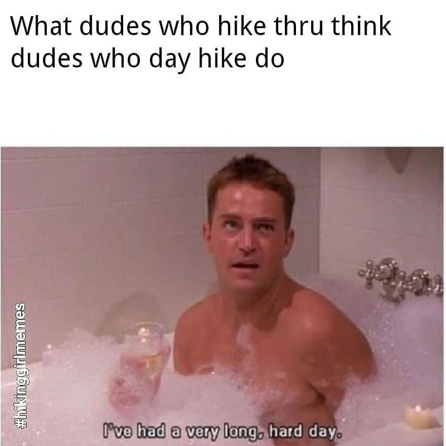 Man relaxing in a bubble bath with a drink, illustrating hiking and camping memes about long, hard day experiences.