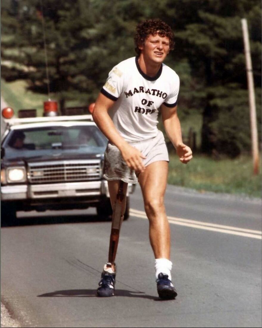 Terry Fox during his Marathon of Hope, a fascinating moment in history, running with a prosthetic leg and a police escort.