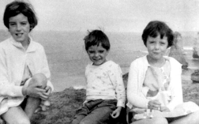 Black and white photo of three children at the beach, evoking creepy and mysterious vibes people lose sleep over.