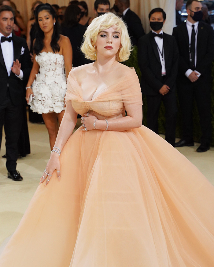 Billie Eilish on the Met Gala red carpet, wearing a voluminous peach gown, exemplifying celebrities at the Met Gala.