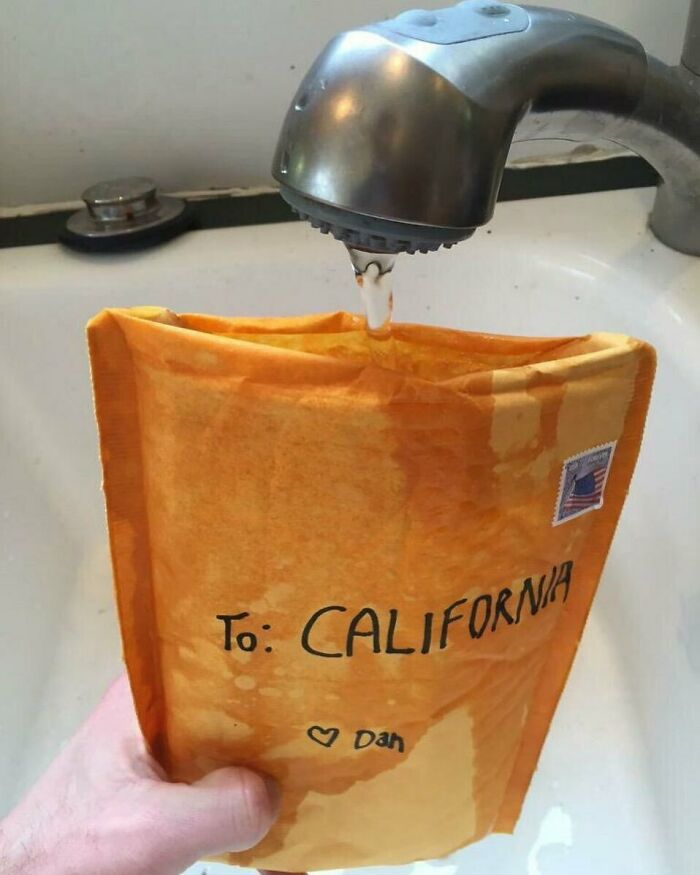 A person fills a mailing envelope addressed to California with water from a sink faucet, creating a cursed image.