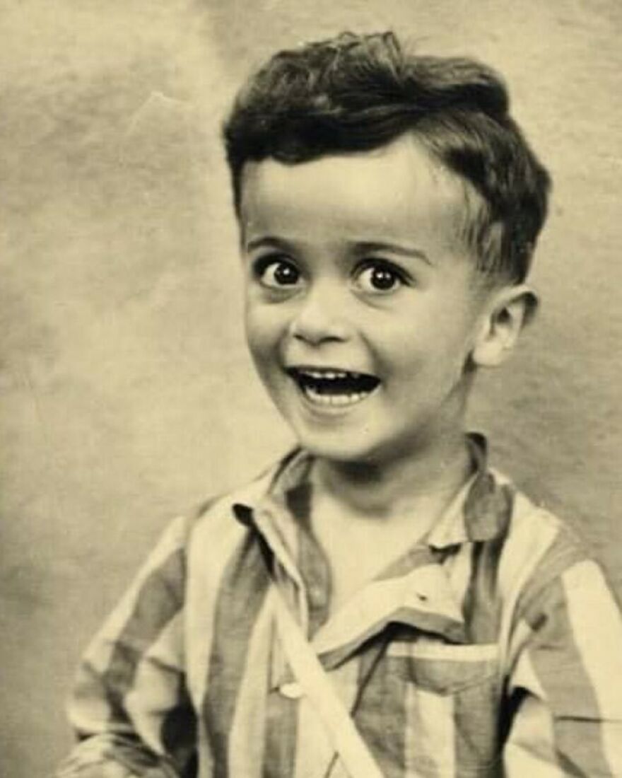 Sepia-toned photo of a young boy with wide eyes and an open-mouthed smile, wearing a striped shirt. Fascinating photos about history.