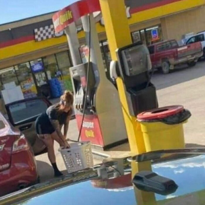 A woman in black shorts at a gas station with a laundry basket, a cursed image that is confusing and amusing.