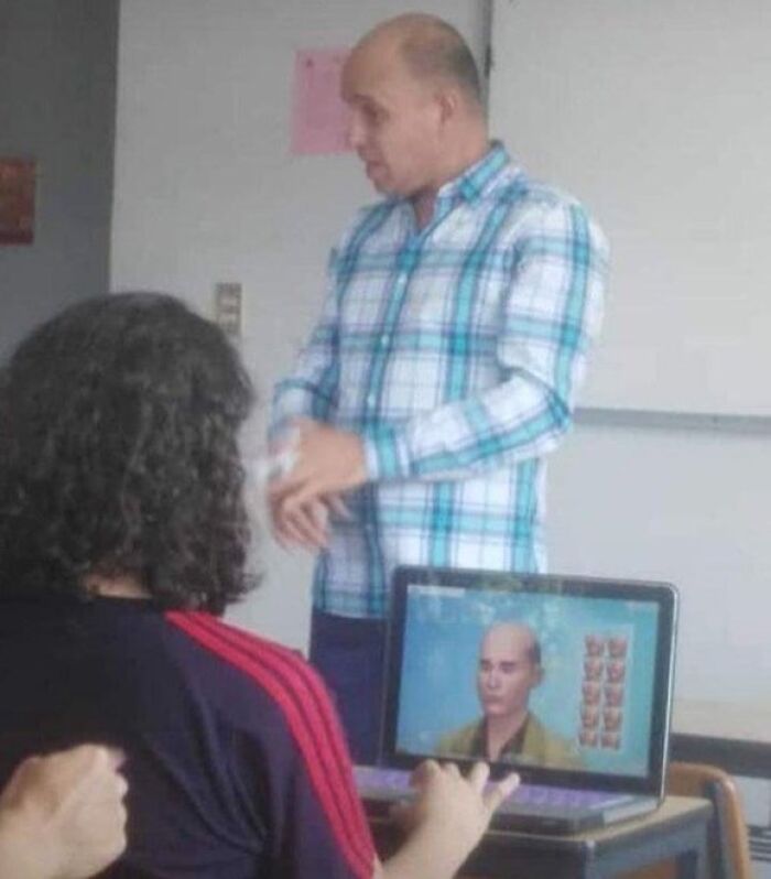 A cursed image of a student playing a game featuring a character resembling their bald teacher in a classroom.