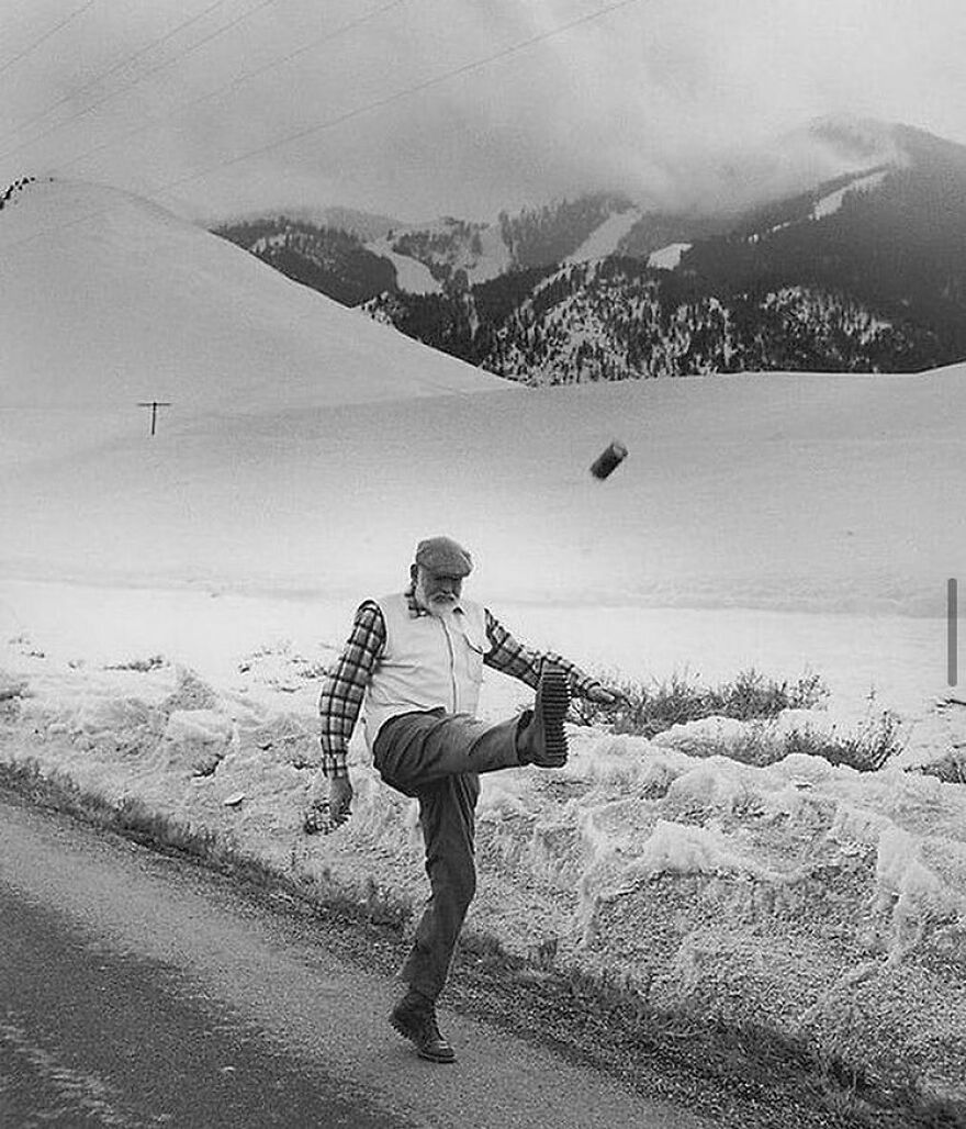 Fascinating photo of an elderly man kicking a can in a snowy mountain landscape, offering a glimpse into history.