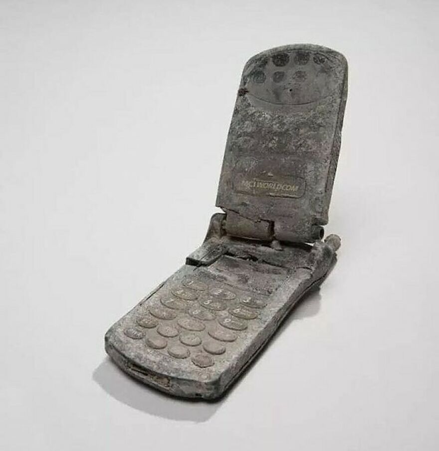 A heavily corroded, open flip phone showing its age, teaching about history through fascinating photos.