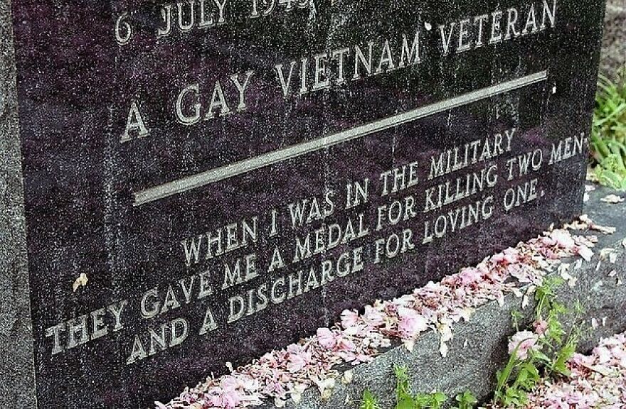 A gravestone for a Gay Vietnam Veteran, engraved with a powerful message about history and love, covered in fallen pink petals. Fascinating photos.
