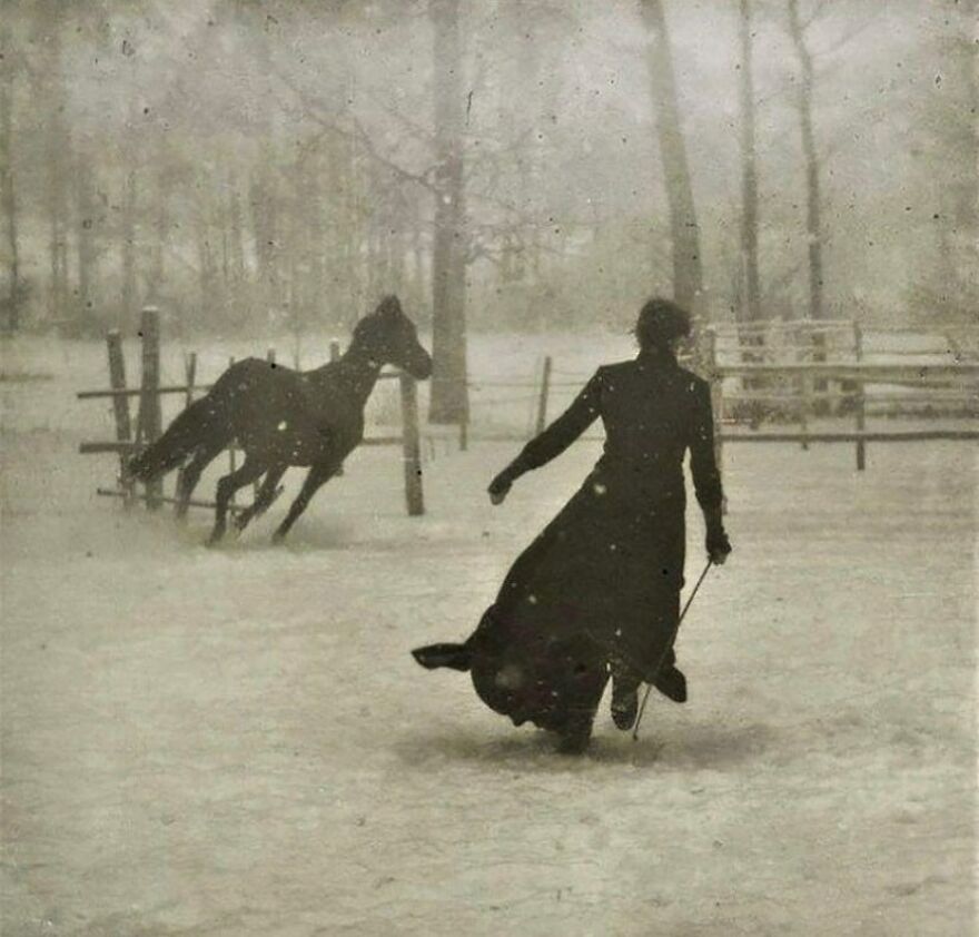 Vintage photo of a woman in a long coat leading a horse in a snowy field. Fascinating photos of history.