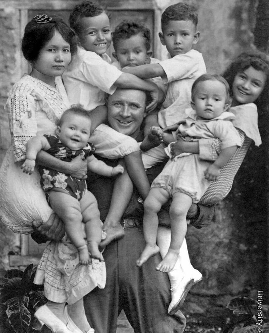A black and white photo of a man and woman holding several young children, offering fascinating photos about history.