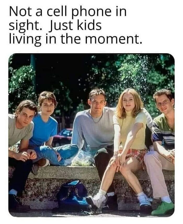 Group of ’90s kids sitting outdoors, enjoying the moment without cell phones, evoking ’90s memes and nostalgia.