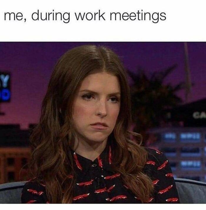 Woman with long brown hair looking bored during work meeting, illustrating hilarious relatable memes about adulthood challenges.
