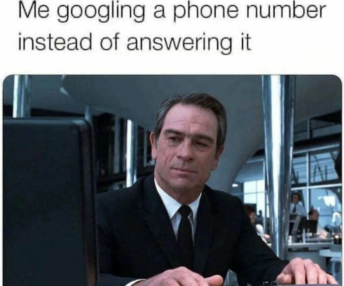 Man in suit looking at computer screen illustrating relatable adulting meme about avoiding phone calls by googling numbers.