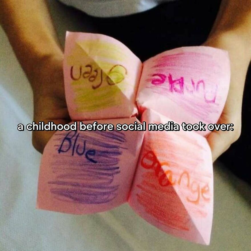 A child's hands hold a paper fortune teller with colors written on it, embodying the vibe of growing up in the 2000s.
