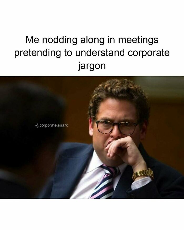 Man wearing glasses and a suit nodding in a work meeting pretending to understand corporate jargon work meme.
