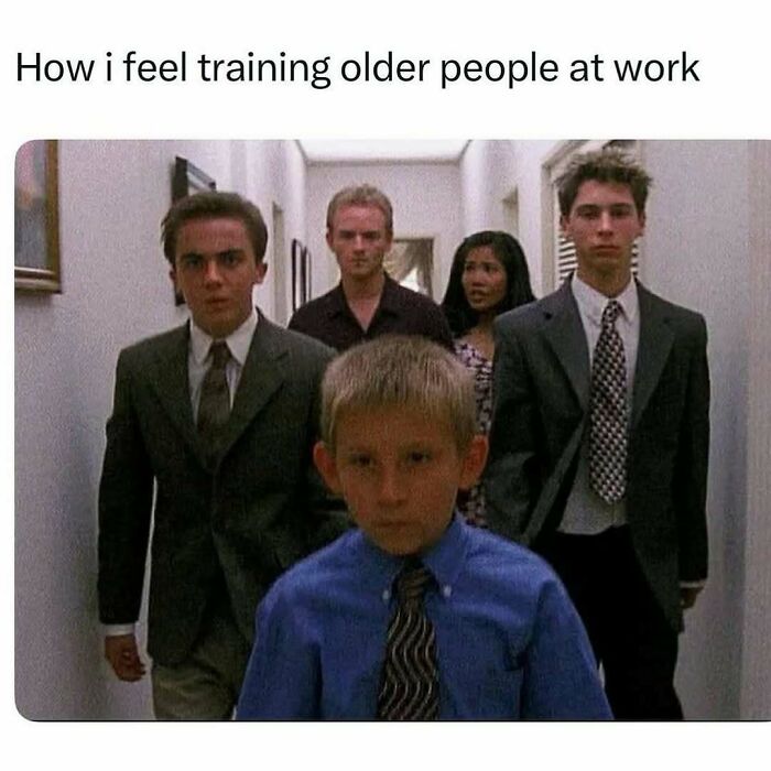 Group of serious young people in suits walking down a hallway, representing meme scrolling humor about training older coworkers.