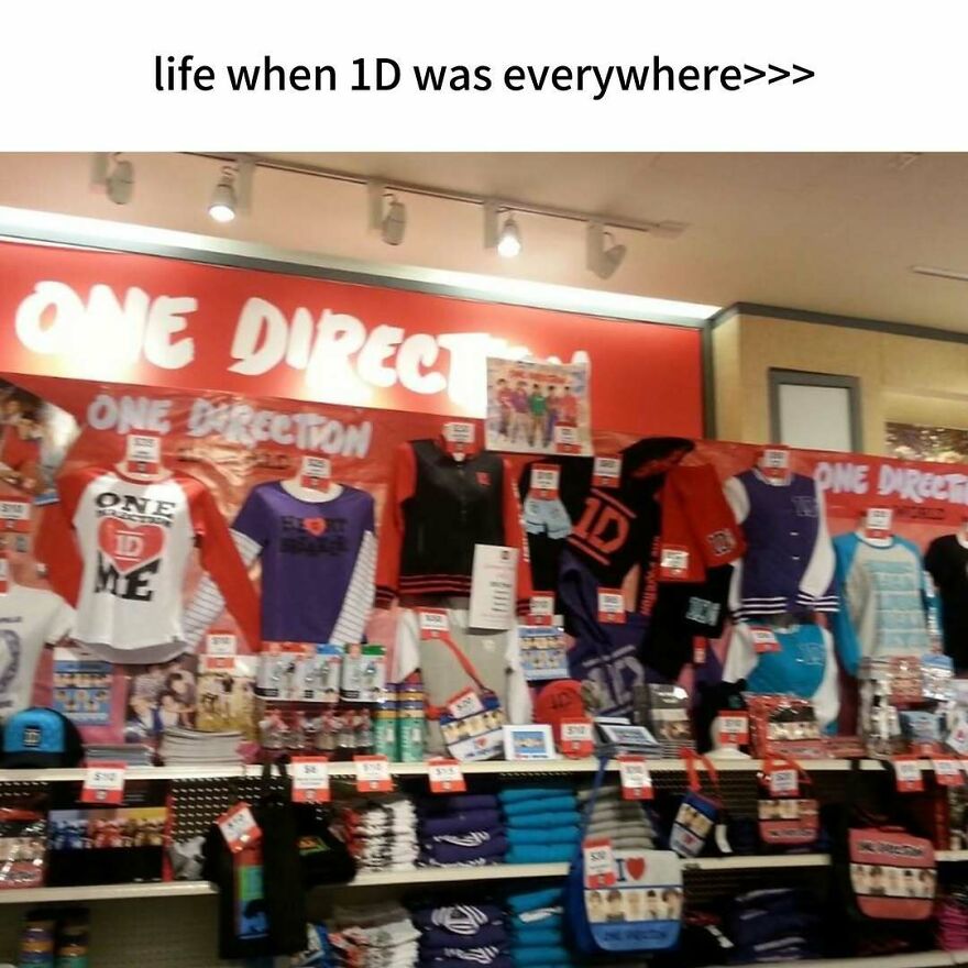 A store display featuring numerous One Direction merchandise, from shirts to accessories. A nostalgic photo capturing the vibe of growing up in the 2000s.