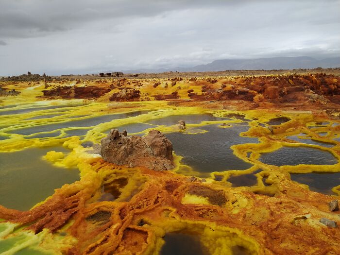 Unbelievable photos of Danakil Depression, Ethiopia, with vibrant yellow and orange mineral deposits surrounding pools of water.