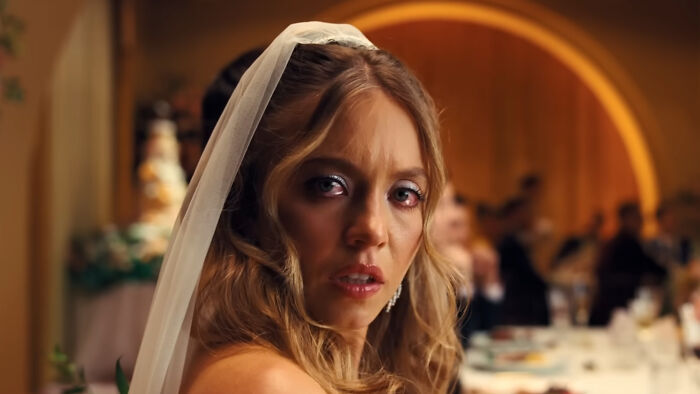 Sydney Sweeney in Euphoria, wearing a wedding veil and tears in her eyes, looking distressed at a wedding reception.