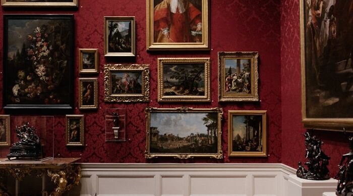 Gallery wall with framed classical paintings and sculptures, illustrating brain-scratching general knowledge questions theme.