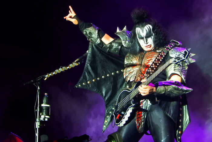 Gene Simmons of KISS performs live, dressed in full costume, playing bass guitar. The image evokes wild rumors.