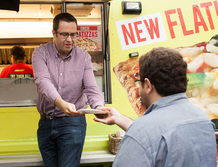 Man handing food to customer at food truck counter, illustrating common PR mistakes companies didn’t expect to backfire