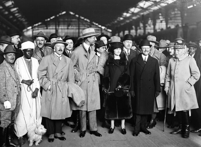 Group of men and a woman in early 20th century attire, a rare and interesting photo from a time we cannot experience today.