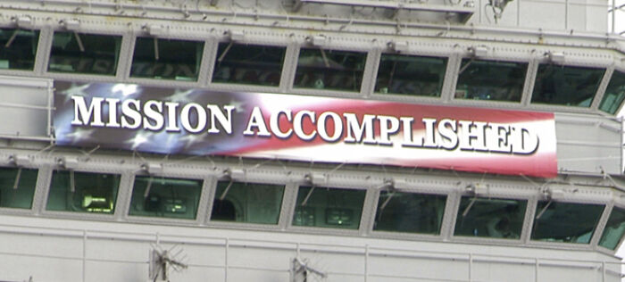 Banner with the phrase mission accomplished displayed on a building representing PR mistakes that backfire for companies.