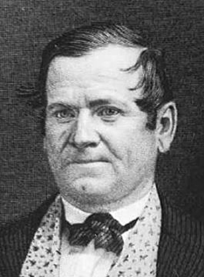 Black and white portrait of a man, possibly a celebrity relative, in formal attire, discussing costs and honest stories.