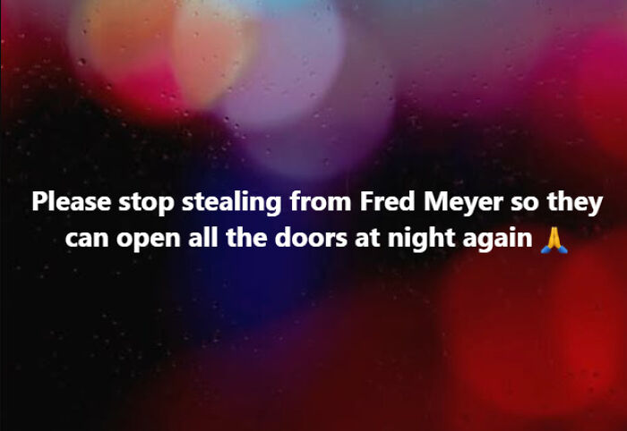 A meme on a blurry, colorful background with text, "Please stop stealing from Fred Meyer so they can open all the doors at night again 🙏." Relatable Alaska meme.