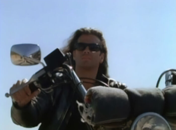 Man wearing sunglasses and leather jacket riding a motorcycle, evoking two 80s icons now in their 60s fan frenzy. Man wearing sunglasses and leather jacket riding a motorcycle, evoking two 80s icons now in their 60s fan frenzy.