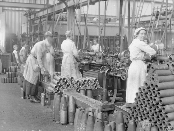 Women working in a factory assembling artillery shells during a rare and interesting moment in history.