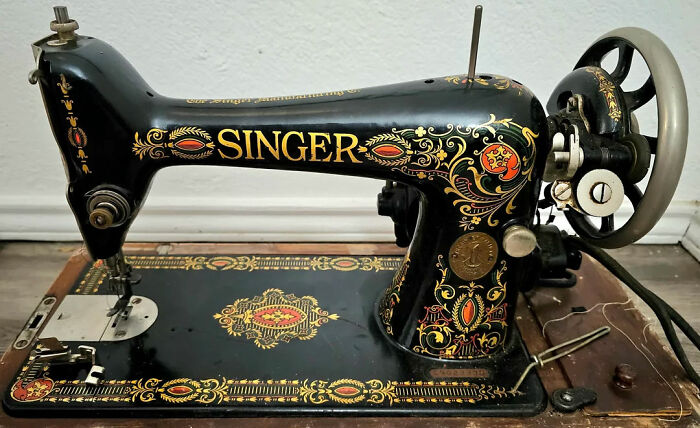 A vintage black Singer sewing machine with intricate gold, red, and green designs, an unusual possession, showing its true value.