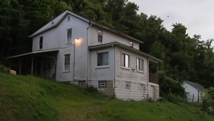 Uma casa branca numa colina gramada, cercada por árvores. O desaparecimento da criança de 9 anos leva a várias prisões.
