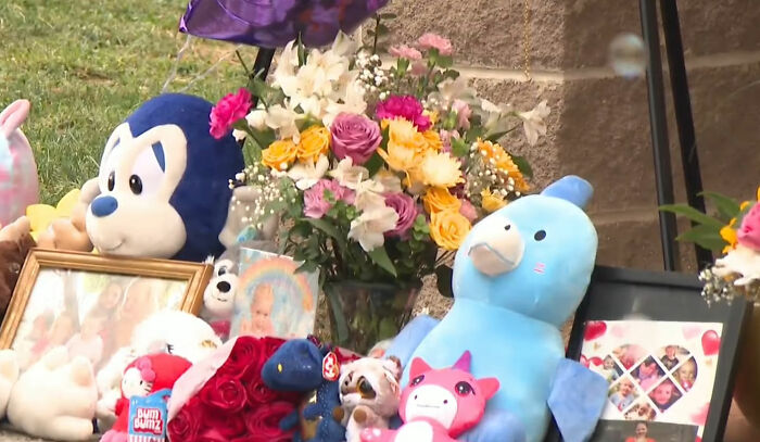 Um memorial com flores, bichos de pelúcia e fotos emolduradas pelo desaparecimento de uma criança de 9 anos, refletindo a dor da comunidade.