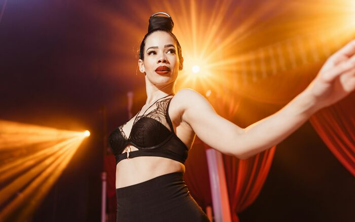 Woman in black lingerie dancing under bright lights at a wild and unforgettable bachelor and bachelorette party event