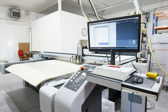 Industrial computer-controlled cutting machine in a factory, highlighting jobs that AI can’t touch in manufacturing.