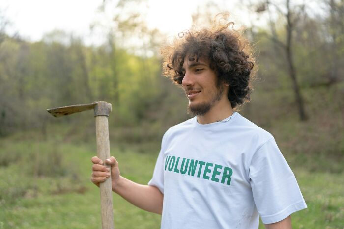 Young volunteer holding a gardening tool outdoors, symbolizing resilience and overcoming horrible bullies in life.