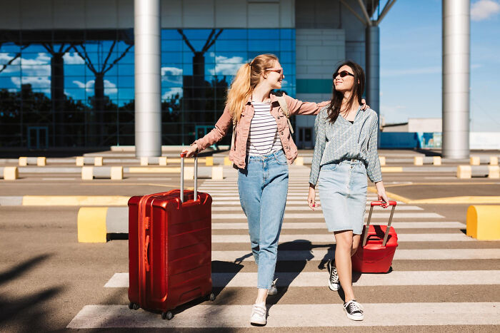 Two women walking with suitcases outside an airport, illustrating real life plot twists families couldn't imagine.