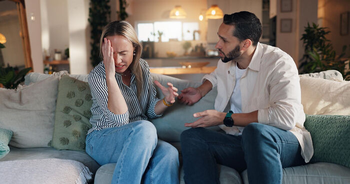 Couple having an intense argument on a couch, illustrating real life plot twists and family relationship surprises.