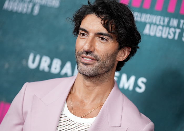 Man with dark curly hair wearing a pink blazer and white shirt at an event, related to Blake Lively's scathing lawsuit statement.